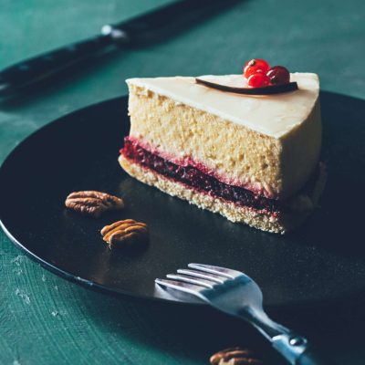close up view of piece of cake on plate with hazelnuts and fork